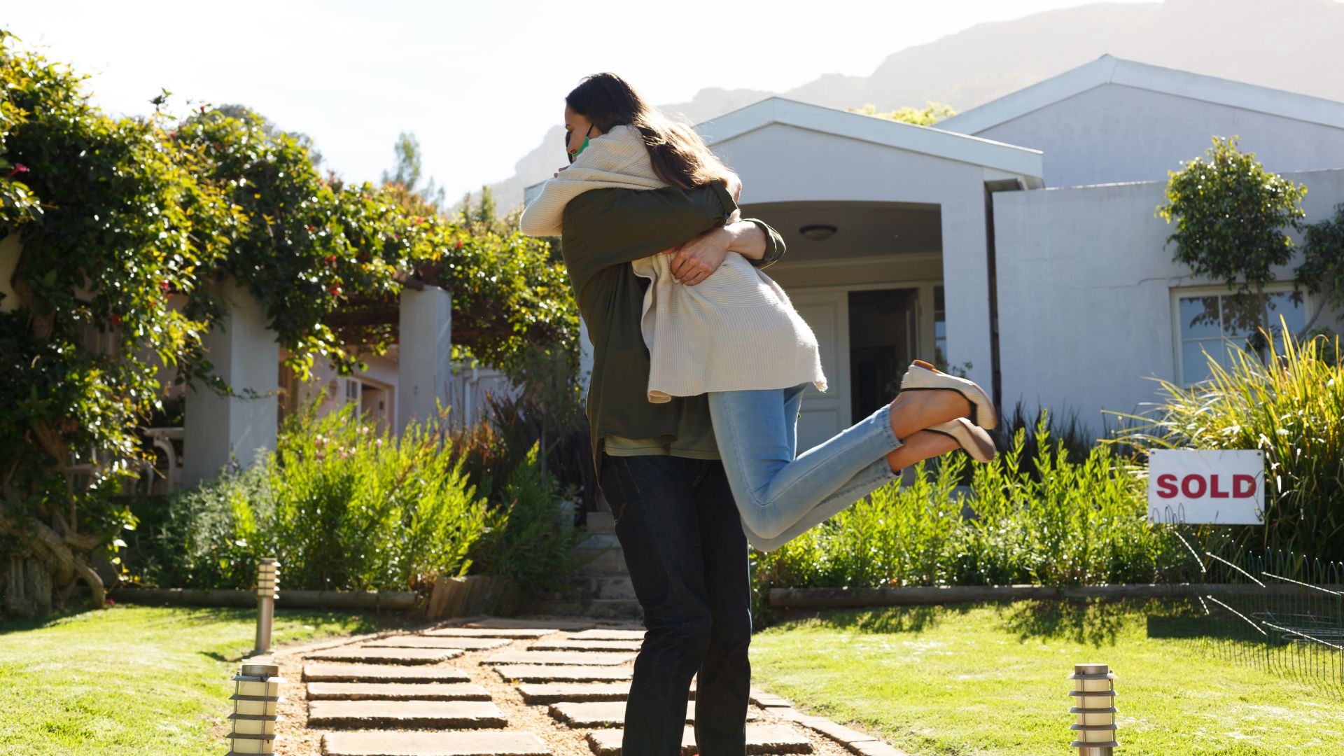 A couple celebrating in front of a house